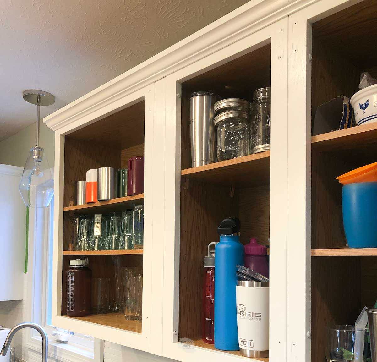 white cabinet frames with kitchen cabinet doors missing.