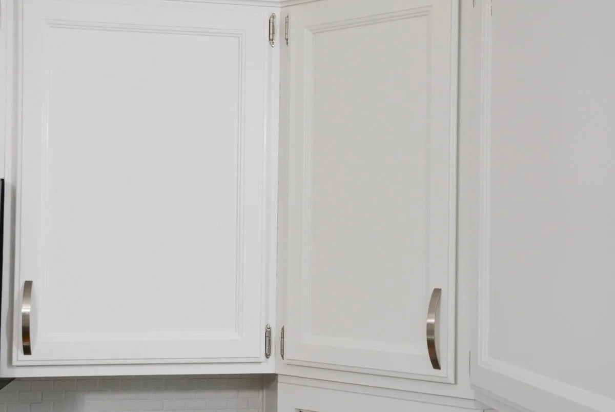 upper oak doors kitchen cabinet doors painted white with silver hinges and hardware.